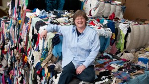 SVdP staff member Gayla sitting on baled textiles